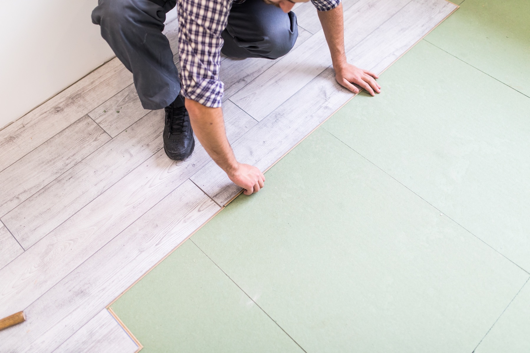 Worker installing laminate flooring
